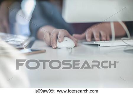 Businesswoman sitting at desk, using computer, mid section View Large Photo Image Stock Photograph - Businesswoman sitting at desk, using computer, mid section. Fotosearch