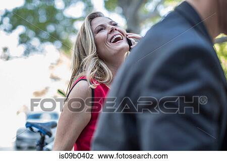 Businesswoman talking and laughing on cellphone in city View Large Photo Image Stock Photo - Businesswoman talking and laughing on cellphone in city. Fotosearch