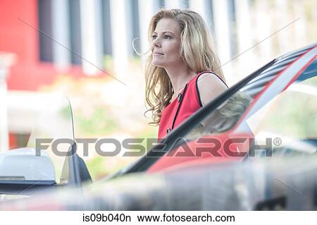 Businesswoman waiting next to car in city View Large Photo Image Picture - Businesswoman waiting next to car in city. Fotosearch