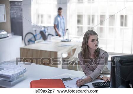 Businesswoman working at computer in loft office View Large Photo Image Stock Photo - Businesswoman working at computer in loft office. Fotosearch