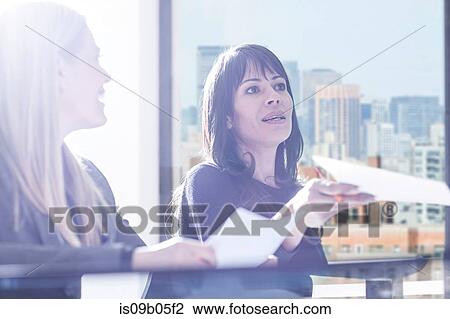 Businesswomen chatting in office View Large Photo Image Stock Image - Businesswomen chatting in office. Fotosearch