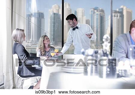 Stock Image - Businesswomen having breakfast in hotel restaurant. Fotosearch