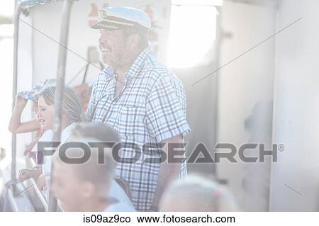 Picture - Captain and tourists looking out on boat trip, Cape Town, South Africa. Fotosearch