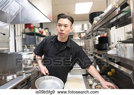 Stock Photo - Chef cooking in commercial kitchen. Fotosearch