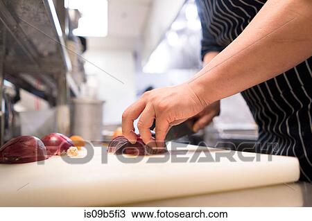 Stock Image - Chef in kitchen preparing food. Fotosearch