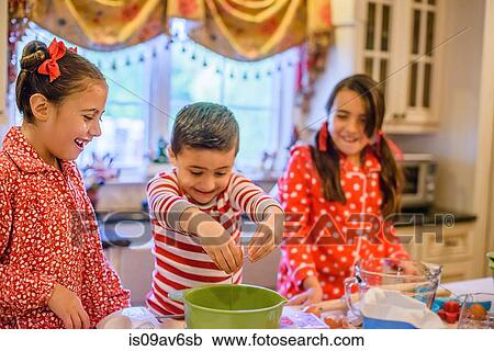 Children in kitchen wearing pyjamas cracking eggs into mixing bowl smiling View Large Photo Image Stock Image - Children in kitchen wearing pyjamas cracking eggs into mixing bowl smiling. Fotosearch