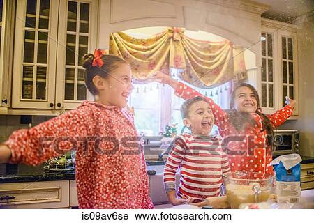 Children in kitchen wearing pyjamas arms open looking away smiling View Large Photo Image Stock Image - Children in kitchen wearing pyjamas arms open looking away smiling. Fotosearch