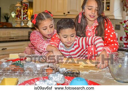 Children in kitchen wearing pyjamas rolling out dough with rolling pin View Large Photo Image Stock Image - Children in kitchen wearing pyjamas rolling out dough with rolling pin. Fotosearch