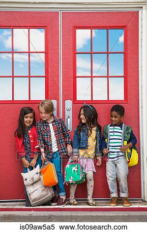 Stock Photography - Children outside elementary school on first day of school. Fotosearch