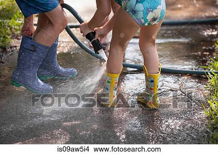 Children playing with water hose on sidewalk View Large Photo Image Picture - Children playing with water hose on sidewalk. Fotosearch