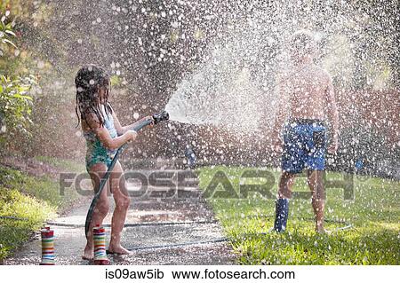 Children playing with water hose on sidewalk View Large Photo Image Stock Image - Children playing with water hose on sidewalk. Fotosearch