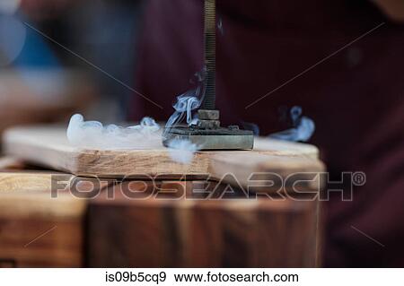 Close up of branding iron burning imprint onto chopping board in factory View Large Photo Image Stock Photo - Close up of branding iron burning imprint onto chopping board in factory. Fotosearch