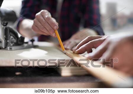 Stock Photography - Close up of carpenters marking measurements in furniture making workshop. Fotosearch