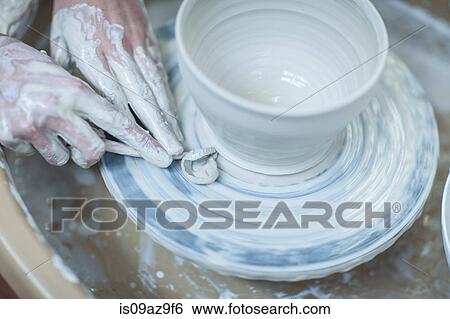 Close up of female potter's hands scraping clay bowl on pottery wheel in workshop View Large Photo Image Stock Photograph - Close up of female potter's hands scraping clay bowl on pottery wheel in workshop. Fotosearch