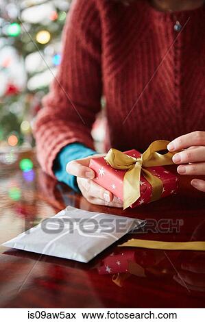 Close up of womans hands wrapping xmas gift at table View Large Photo Image Stock Photo - Close up of womans hands wrapping xmas gift at table. Fotosearch