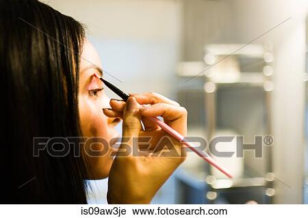 Close up of young woman putting on eye shadow with brush View Large Photo Image Stock Image - Close up of young woman putting on eye shadow with brush. Fotosearch