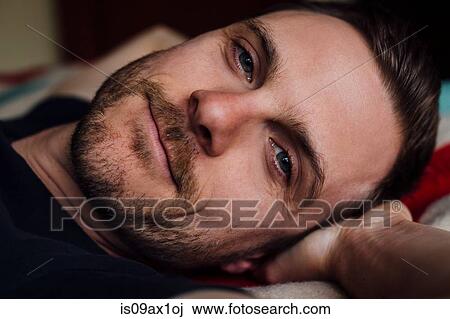 Close up portrait of handsome confident man on bed with hands behind head View Large Photo Image Stock Image - Close up portrait of handsome confident man on bed with hands behind head. Fotosearch