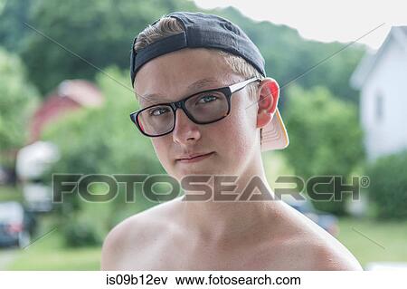 Stock Photo - Close up portrait of teenage boy wearing tinted glasses in garden. Fotosearch