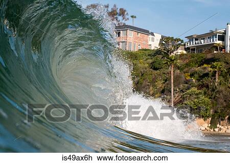 Stock Image - Close up surface level view of rolling wave and beach, Laguna Beach, California, USA. Fotosearch