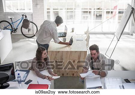 Colleagues having discussion in loft office View Large Photo Image Stock Photo - Colleagues having discussion in loft office. Fotosearch