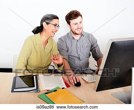 Colleagues looking at computer monitor smiling View Large Photo Image Stock Image - Colleagues looking at computer monitor smiling. Fotosearch