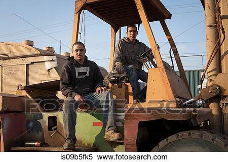 Colleagues on construction site sitting on heavy machinery View Large Photo Image Stock Photography - Colleagues on construction site sitting on heavy machinery. Fotosearch