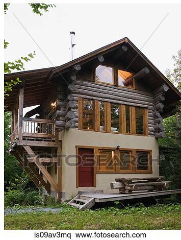 Cottage style log home facade with beige stucco finish and timber wood balcony in summer View Large Photo Image Stock Photography - Cottage style log home facade with beige stucco finish and timber wood balcony in summer. Fotosearch