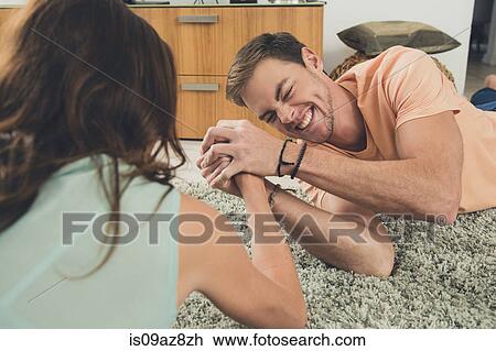 Couple arm wrestling on carpet View Large Photo Image Stock Image - Couple arm wrestling on carpet. Fotosearch