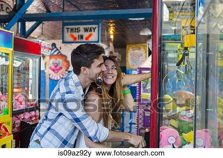 Couple at amusement park using arcade grabber, Coney island, Brooklyn, New York, USA View Large Photo Image Stock Photo - Couple at amusement park using arcade grabber, Coney island, Brooklyn, New York, USA. Fotosearch