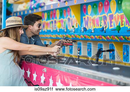 Couple at fairground shooting gallery, Coney island, Brooklyn, New York, USA View Large Photo Image Stock Image - Couple at fairground shooting gallery, Coney island, Brooklyn, New York, USA. Fotosearch
