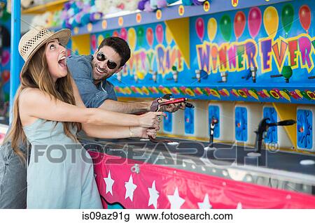 Couple at fairground shooting gallery, Coney island, Brooklyn, New York, USA View Large Photo Image Stock Image - Couple at fairground shooting gallery, Coney island, Brooklyn, New York, USA. Fotosearch