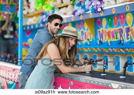 Couple at fairground shooting gallery, Coney island, Brooklyn, New York, USA View Large Photo Image Stock Image - Couple at fairground shooting gallery, Coney island, Brooklyn, New York, USA. Fotosearch