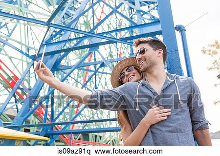 Couple at fairground using smartphone to take selfie, Coney island, Brooklyn, New York, USA View Large Photo Image Stock Photography - Couple at fairground using smartphone to take selfie, Coney island, Brooklyn, New York, USA. Fotosearch