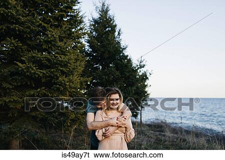 Couple beside water, man hugging woman View Large Photo Image Stock Photograph - Couple beside water, man hugging woman. Fotosearch