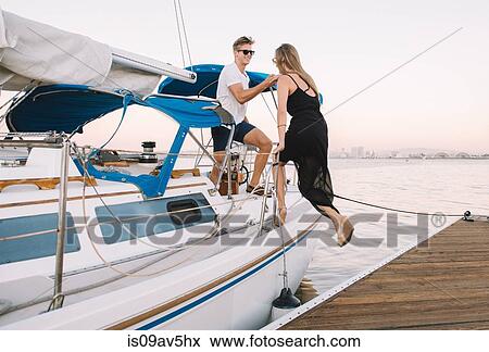 Couple boarding sailboat, San Diego Bay, California, USA View Large Photo Image Stock Photo - Couple boarding sailboat, San Diego Bay, California, USA. Fotosearch