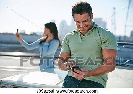 Couple by car using smartphones, Los Angeles, California, USA View Large Photo Image Stock Image - Couple by car using smartphones, Los Angeles, California, USA. Fotosearch