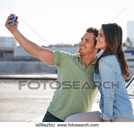 Couple by river taking selfie smiling View Large Photo Image Stock Photograph - Couple by river taking selfie smiling. Fotosearch
