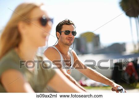 Stock Image - Couple cycling at Venice Beach, Los Angeles, California, USA. Fotosearch
