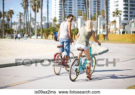 Couple cycling together at Venice Beach, Los Angeles, California, USA View Large Photo Image Stock Photograph - Couple cycling together at Venice Beach, Los Angeles, California, USA. Fotosearch