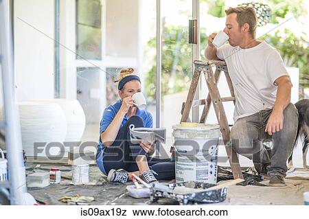Stock Photo - Couple decorating, taking a coffee break. Fotosearch