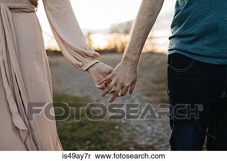 Couple holding hands, outdoors, mid section, close-up View Large Photo Image Stock Photography - Couple holding hands, outdoors, mid section, close-up. Fotosearch