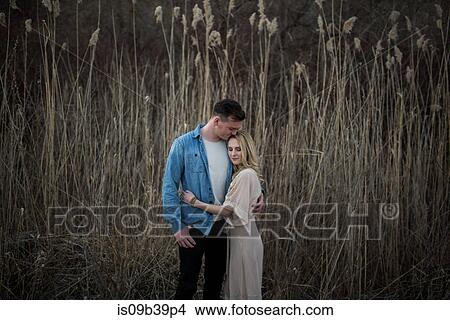 Couple hugging and kissing, tall grass field in background, Ottawa, Ontario View Large Photo Image Picture - Couple hugging and kissing, tall grass field in background, Ottawa, Ontario. Fotosearch
