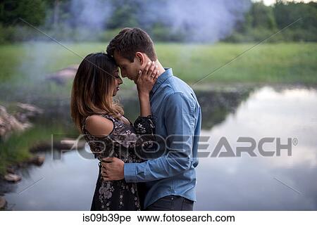 Stock Image - Couple hugging by lake, Ottawa, Ontario. Fotosearch
