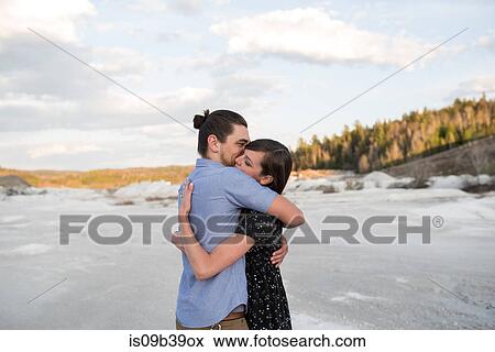 Stock Photo - Couple hugging on snow-covered landscape, Ottawa, Ontario. Fotosearch