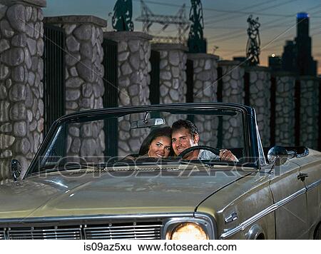 Couple in convertible car at dusk View Large Photo Image Stock Photograph - Couple in convertible car at dusk. Fotosearch