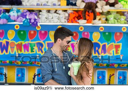 Couple in front of fairground shooting gallery face to face smiling, Coney island, Brooklyn, New York, USA View Large Photo Image Stock Image - Couple in front of fairground shooting gallery face to face smiling, Coney island, Brooklyn, New York, USA. Fotosearch