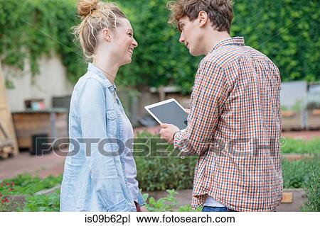 Couple in garden using digital tablet View Large Photo Image Stock Image - Couple in garden using digital tablet. Fotosearch