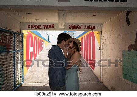 Stock Photo - Couple in tunnel kissing, Coney island, Brooklyn, New York, USA. Fotosearch