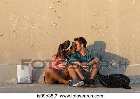 Couple kissing in front of concrete wall View Large Photo Image Stock Photo - Couple kissing in front of concrete wall. Fotosearch