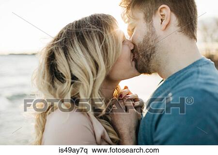 Couple kissing, outdoors, close-up View Large Photo Image Stock Photography - Couple kissing, outdoors, close-up. Fotosearch